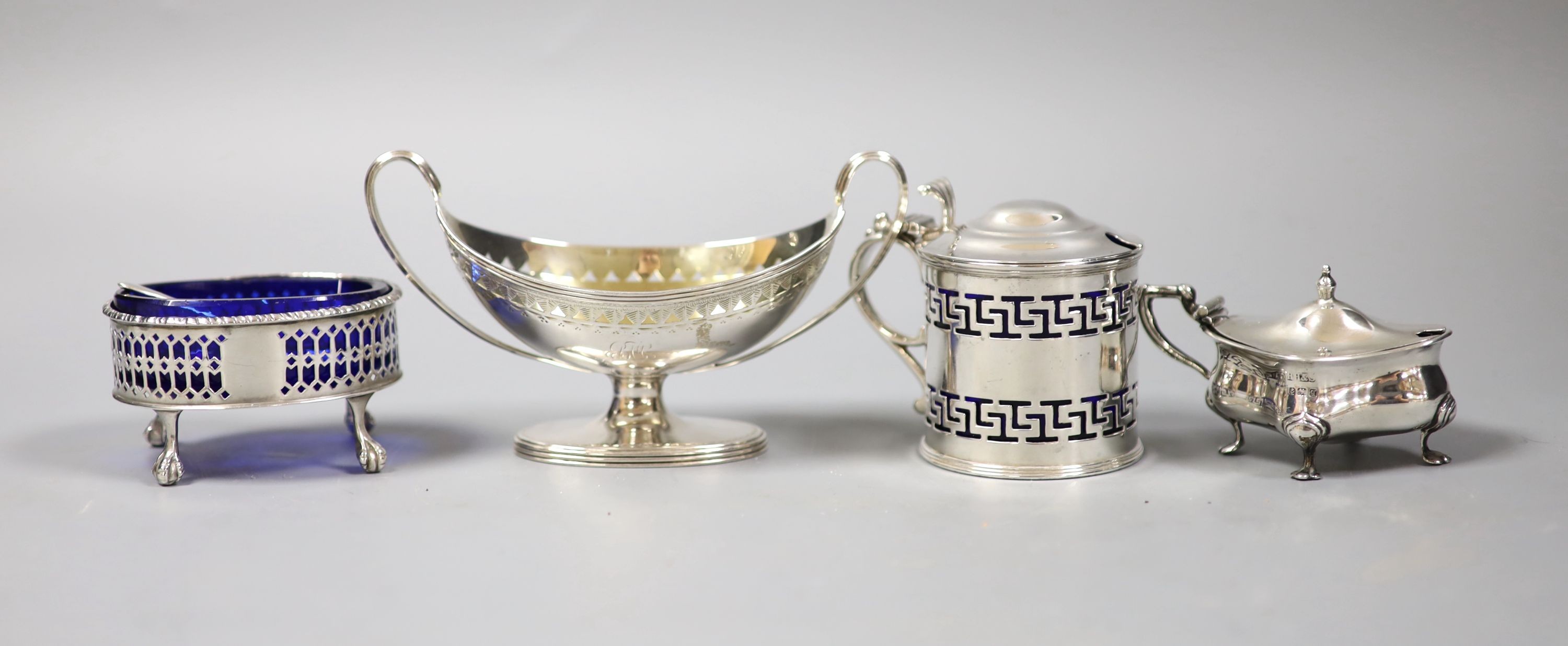 A George III silver two handled boat shaped pedestal salt, London, 179, one other salt and two later silver mustards.